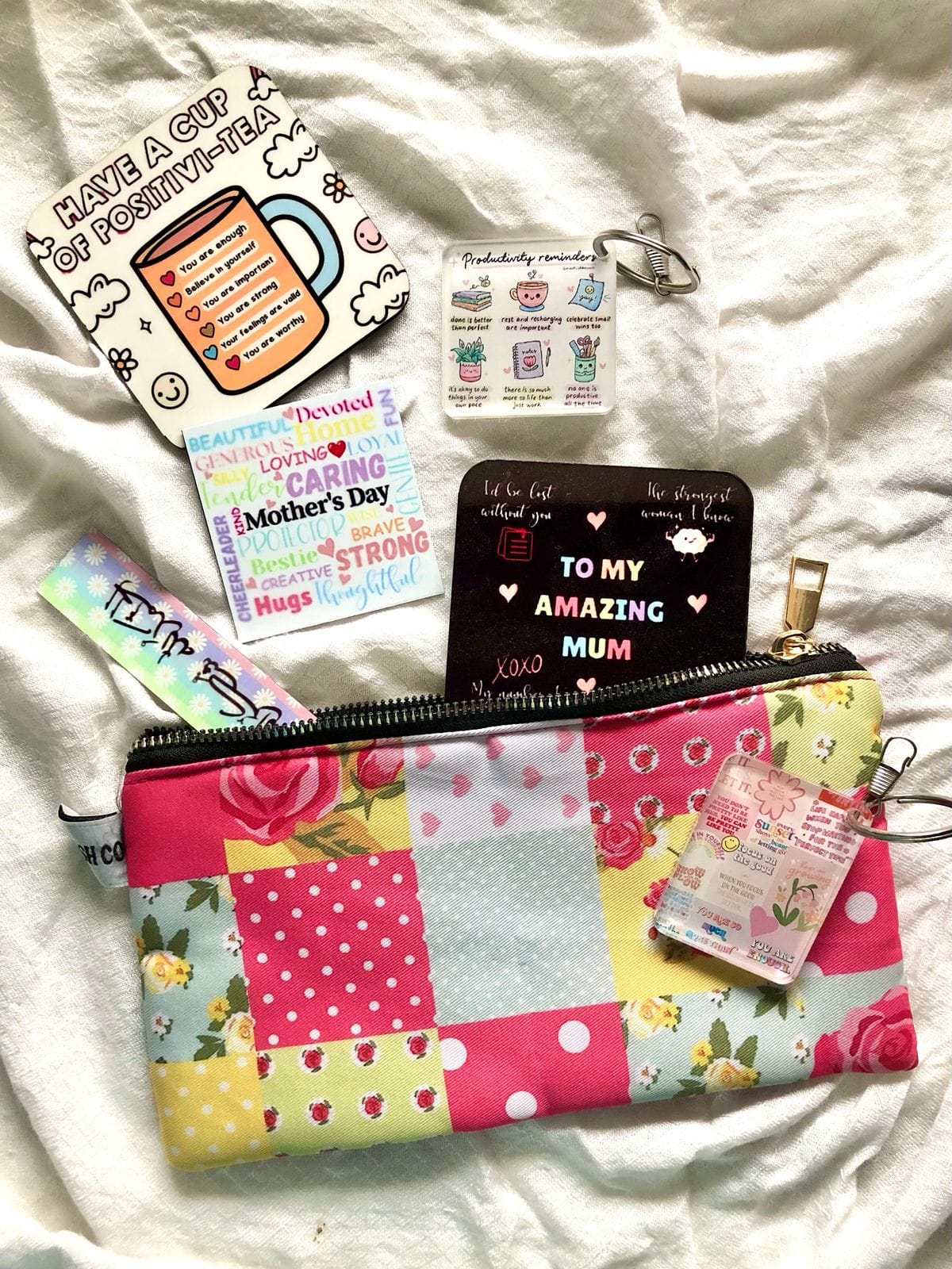 A real floral custom pouch arranged in a personalized gift bundle with a bookmark, keychain, magnets, and card